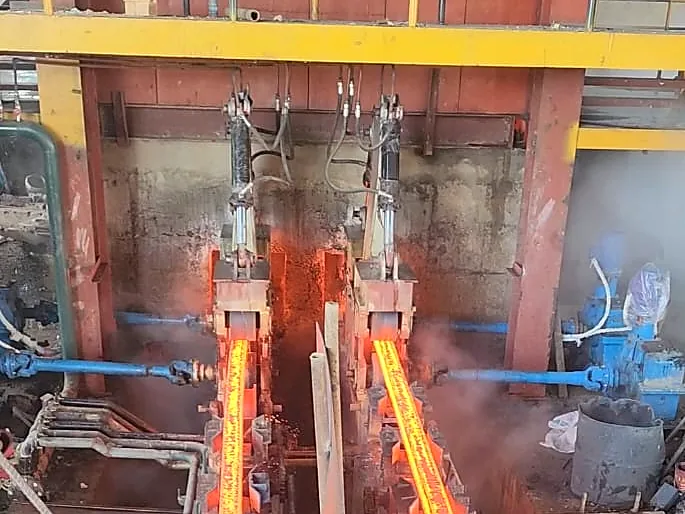 Twin glowing steel bars leaving the rolling stands inside the PSML plant